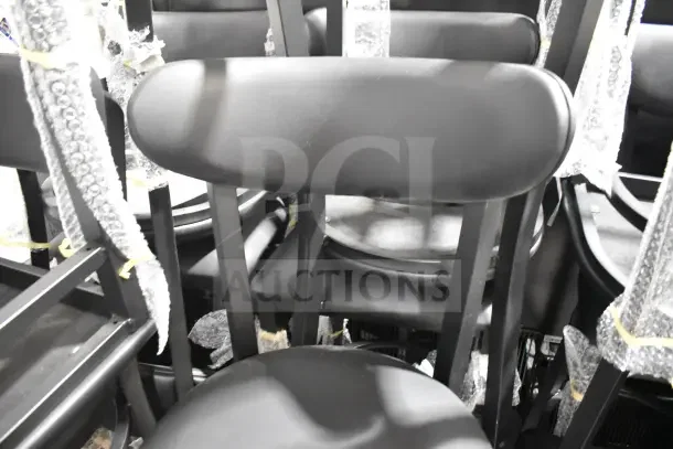 "Brand new Lancaster Boomerang bar stools, black finish, vinyl seat, visible bubble wrap indicating protection."