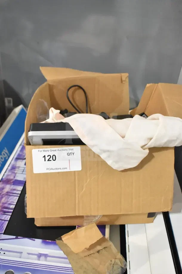 HP LE1711 monitor partially visible in box, wrapped in cloth. Box label reads "120 QTY" by PCI Auctions. Condition unknown.
