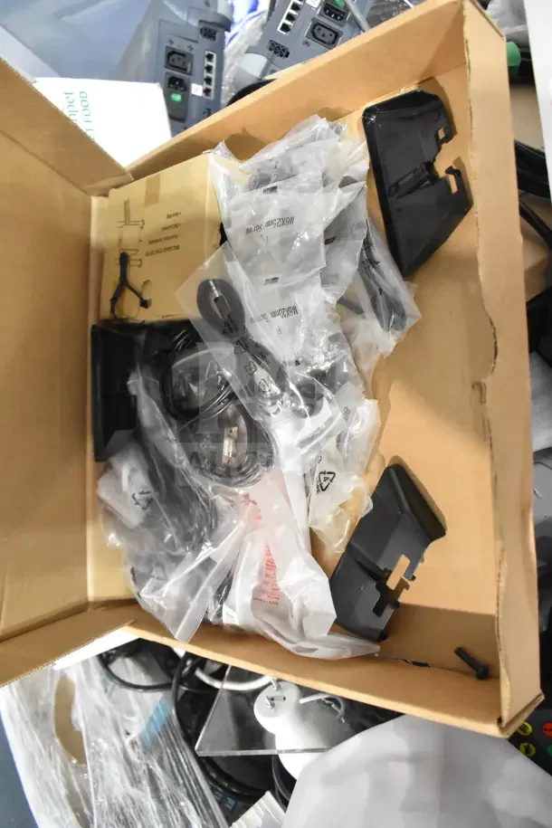 Pallet lot containing various items like a computer keyboard, Sensormatic ZBSMPROE, in mixed condition, shown unboxed.