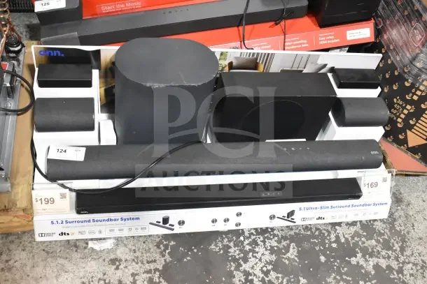Store display featuring various Onn sound bars and speakers, showcasing 5.1.2 surround sound systems with wireless subwoofer. Pricing tags visible.