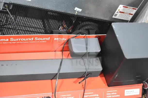 Store display featuring Vizio sound bar and speakers, includes subwoofer. Visible logos and Dolby Atmos branding.