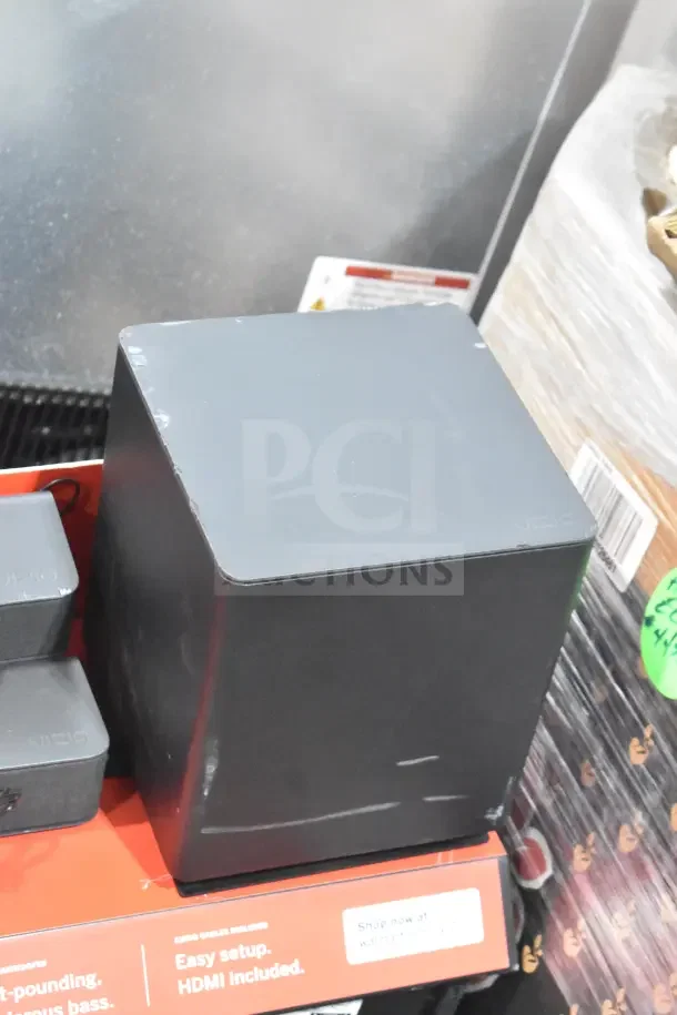 Vizio sound bar and speaker display; includes subwoofer and speakers on a red stand. Visible Vizio logo, in good condition.