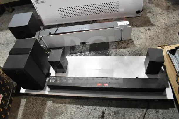 LG sound bar and speakers on store display, featuring HDMI, dts, and Dolby audio support; displays minimal wear.