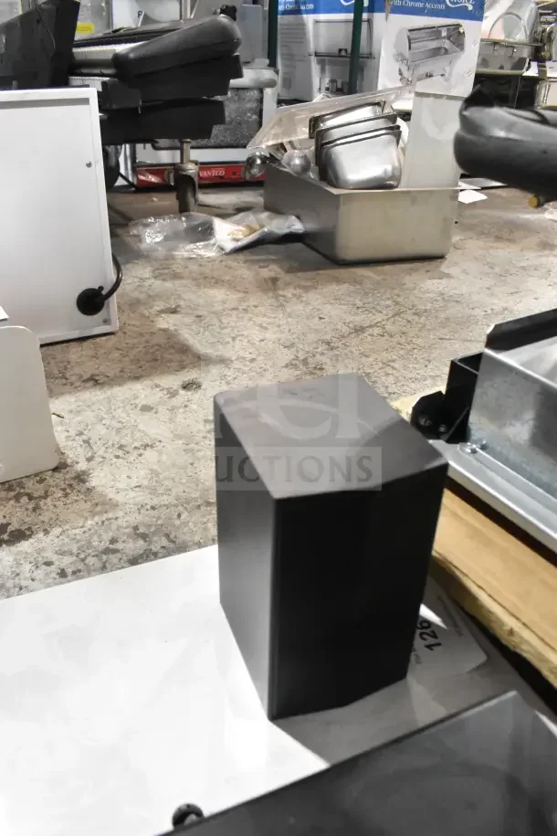 Store display showcasing LG sound bar and speakers, featuring black sleek design; components visible amidst store setting.