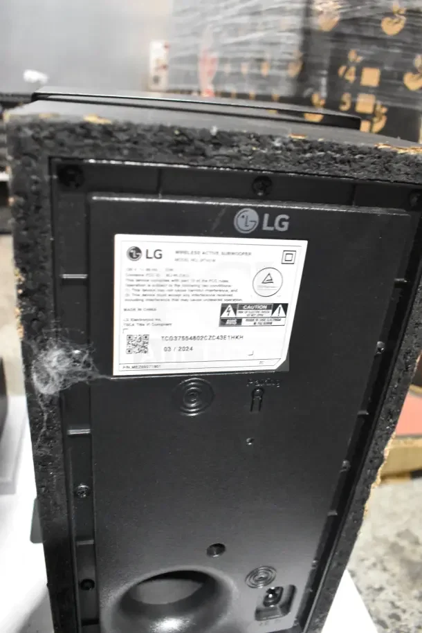 LG sound bar display with wireless active subwoofer, SPC7-W model. Features visible label with specifications.