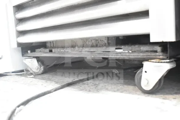 2018 True T-19F-HC Reach In Freezer, single door, on commercial casters, showing lower section and wheels. Dust visible.