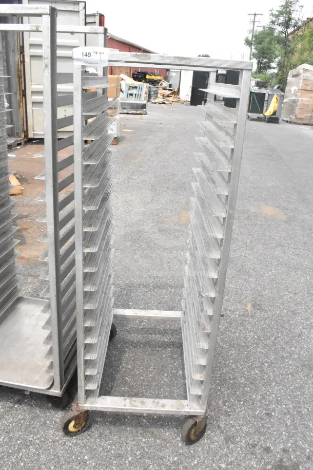 Commercial pan transport rack on durable casters, multiple shelves, silver metal, used condition, label "149 HGT QTY".