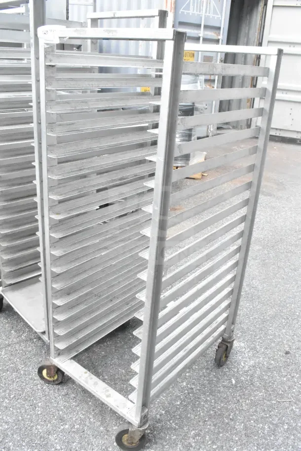 Stainless steel commercial pan transport rack with adjustable shelves on swiveling commercial casters, used condition.