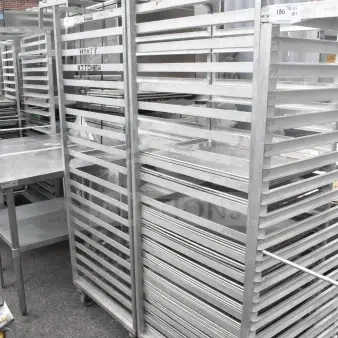Two commercial pan transport racks on casters, includes 40 baking pans. Good condition, ideal for large kitchens.