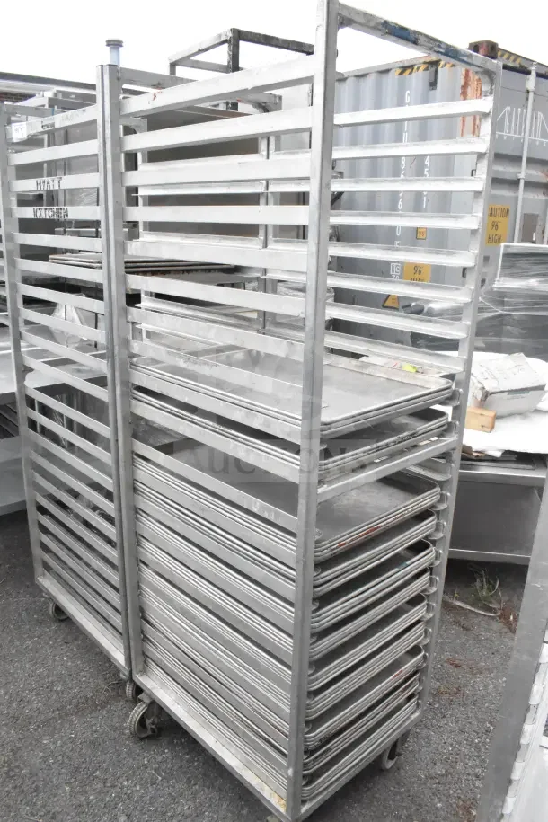 Two commercial pan transport racks on casters with 40 baking pans included. Used condition, ideal for bakery use.