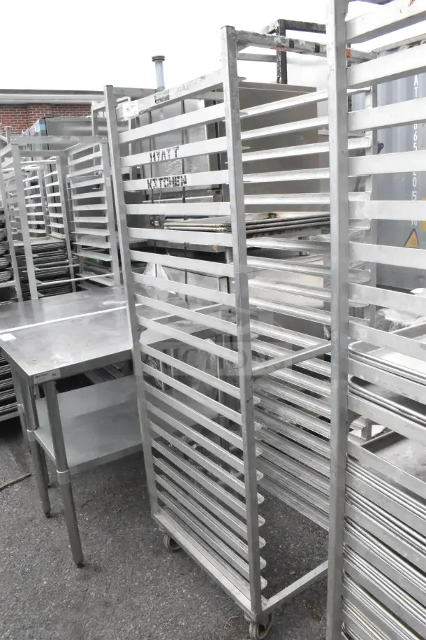 Commercial pan transport rack on casters, slightly worn, includes 40 baking pans. Suitable for industrial kitchens.
