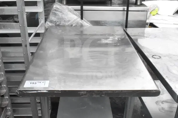 Stainless steel commercial table with under shelf, industrial finish, label marked "153 qty 1", suitable for kitchen use.