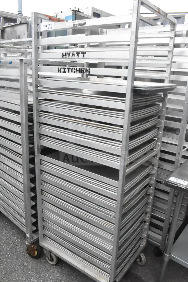 Commercial pan transport rack with 56 baking pans, metal construction, used condition, marked "Hyatt Kitchen."