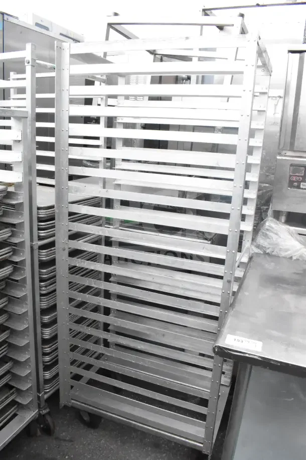 Two commercial pan transport racks with 56 baking pans included. Sturdy metal construction, ideal for high-volume baking.