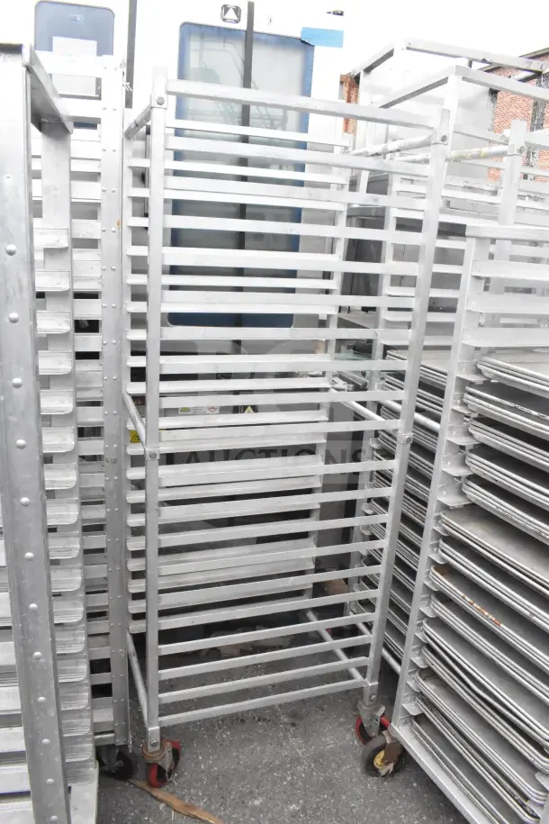Commercial rolling pan transport rack with 20 slots, includes 44 baking pans. Durable metal, used condition.