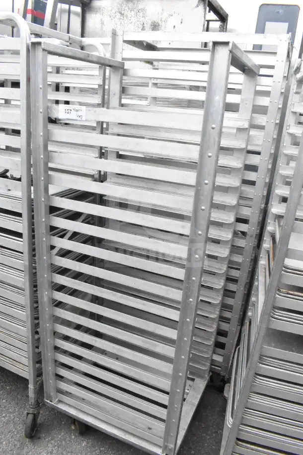 Commercial pan transport rack, sturdy metal, multiple slots for pans, on casters for mobility. Auction includes two racks.