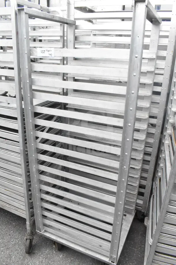 Two commercial aluminum pan transport racks with multiple shelves, on wheels for easy mobility, in good condition.