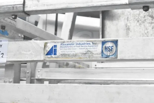 Commercial pan transport rack with 68 baking pans, Alexander Industries label, NSF certified, model E-401, good condition.