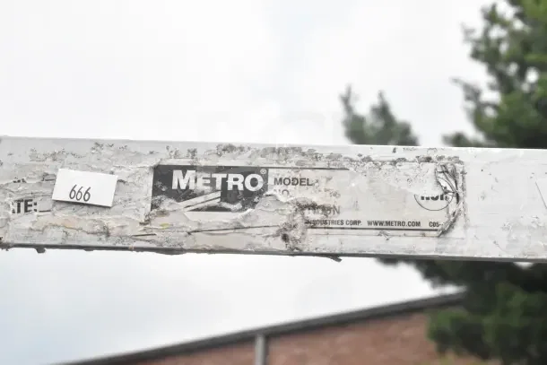 Metro commercial pan transport rack with worn label. Model number obscured. Tag number 666 visible.