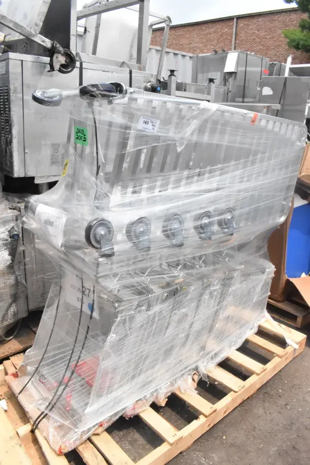 6 brand new scratch and dent items including shopping carts and pan rack, wrapped in plastic, on a wooden pallet.