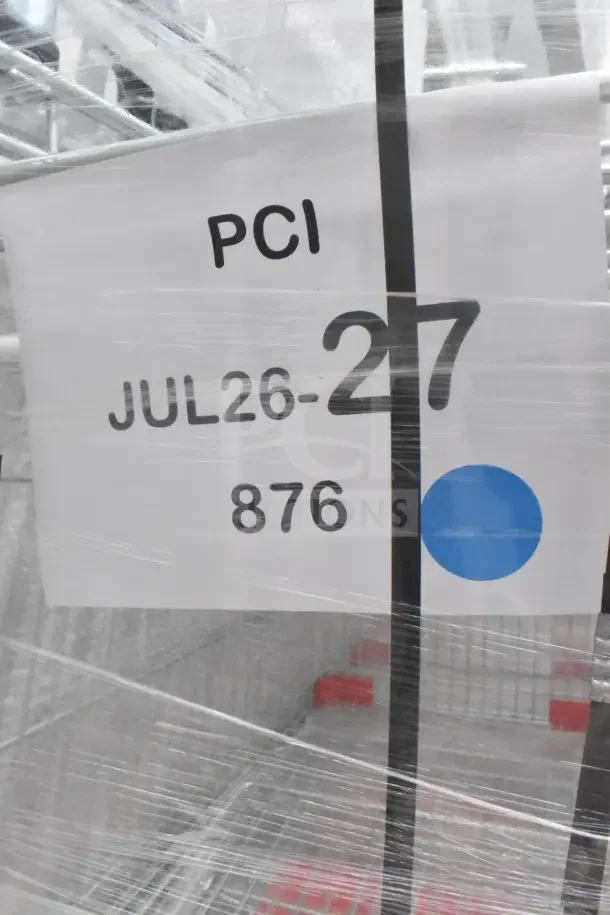 A wrapped pallet labeled "PCI JUL26-27 876," containing scratch and dent items like shopping carts and pan rack.