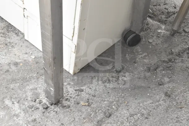 Black and chrome finish table leg on concrete floor, showcasing metallic structure. Appears in good condition. No visible tags.