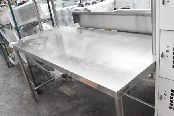 Stainless steel table with over shelf, industrial-grade, sturdy construction, suitable for kitchen or workspace use.