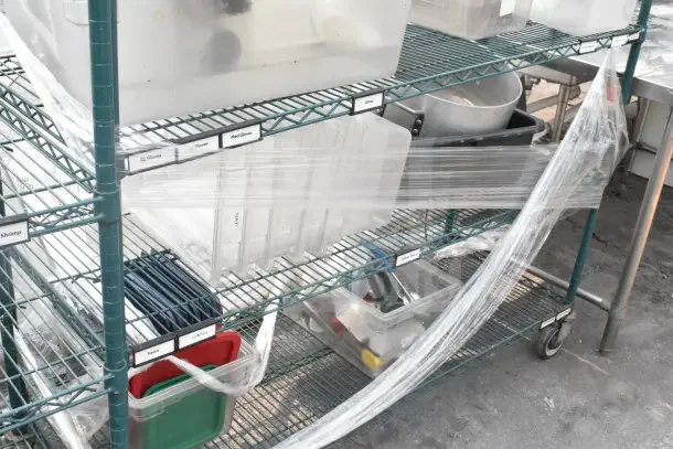 Green 5-tier wire shelving unit on commercial casters with storage bins. Features labels for organization. Buyer must dismantle.