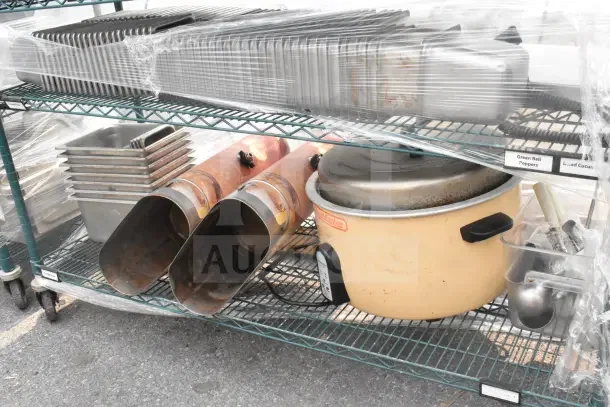 Green 6-tier wire shelving unit on casters with drop-in bins, includes contents like pans and kitchen items. Buyer must dismantle.