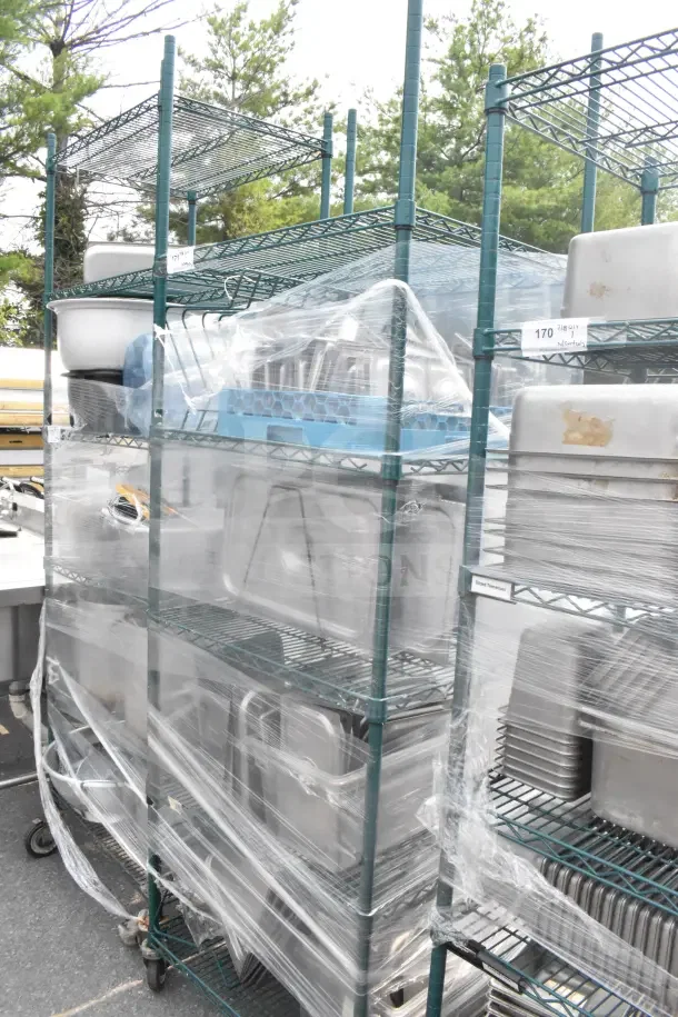 Green finish 5-tier wire shelving unit with commercial casters, wrapped contents including drop-in bin lids, buyer must dismantle.