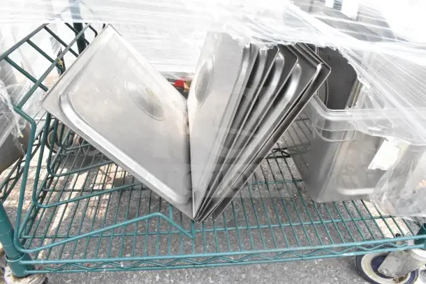 Green 5-tier wire shelving unit on commercial casters with drop-in bin lids. Includes contents. Buyer must dismantle.