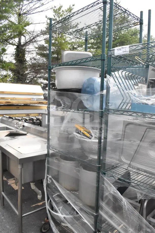 Green finish 6-tier wire shelving unit on commercial casters, filled with utensils and a colander. Buyer dismantles.