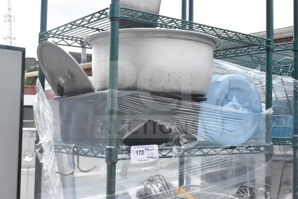 Green 6-tier wire shelving unit on casters, includes utensils and colander, wrapped in plastic; buyer to dismantle.