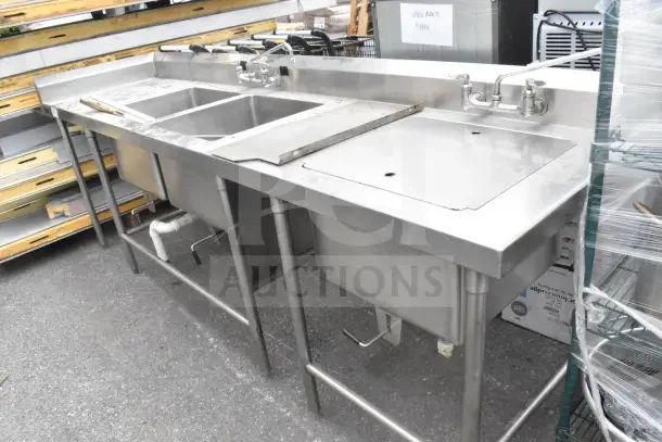 Commercial 2 bay stainless steel sink with extra right side bay, dual faucets, and backsplash; pre-owned.