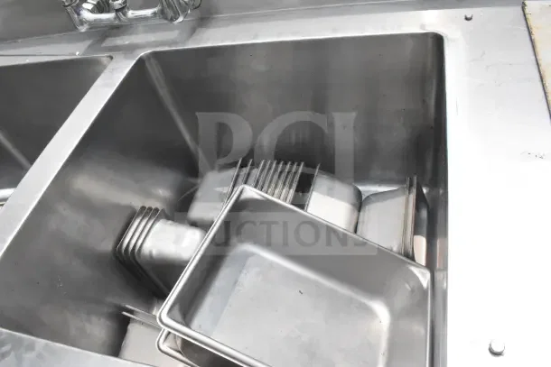 Commercial stainless steel 2-bay sink with extra right side sink bay, featuring multiple compartments and faucet, in used condition.