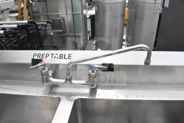 Commercial 2 bay sink with extra right side bay, dual faucets, labeled "PREP TABLE," stainless steel, good condition.