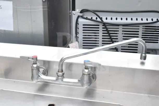 Commercial 2 bay stainless steel sink with additional right side bay. Features dual faucets, ideal for kitchen use.