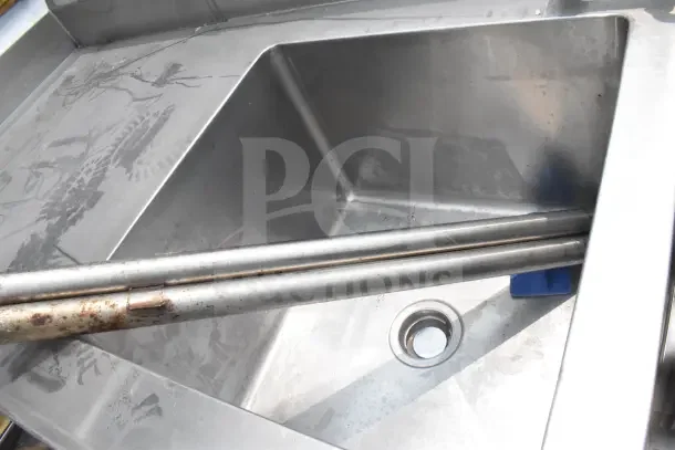 Commercial 2 bay stainless steel sink with extra right side basin, visible strainer, and light surface wear.