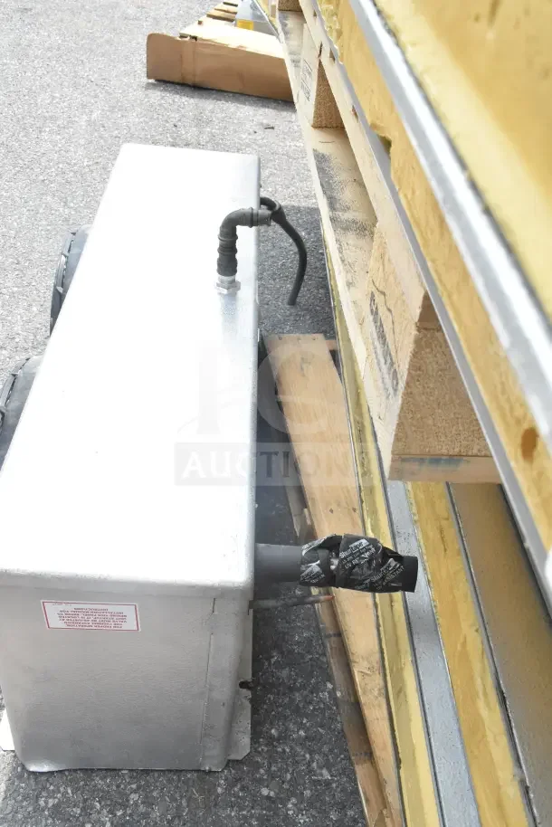 Walk-In Box with Evaporator Fan, silver exterior, attached cables, stacked on wooden pallets, some visible wear.