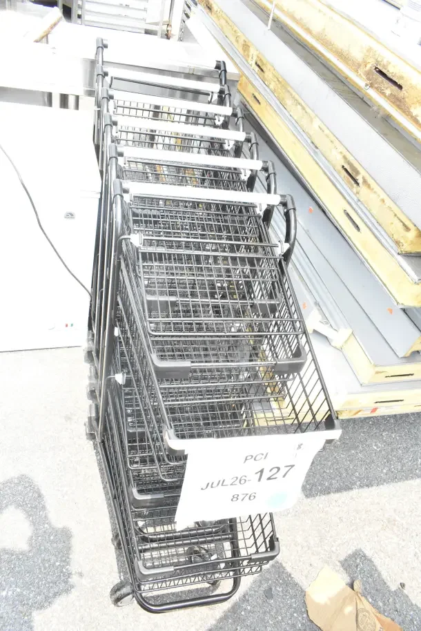6 new Regency 460SHPCRTTTB two-tier black shopping carts, 2.8 cu. ft., displayed with lot tag JUL26-127. Scratch and dent condition.