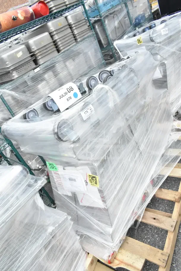 5 brand new Regency supermarket shopping carts, 6.3 cu. ft., scratch and dent, wrapped on a pallet, tags visible.