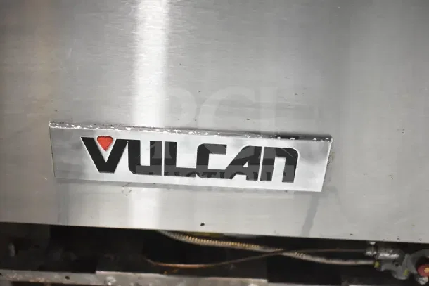 Vulcan commercial gas 4-burner range with oven, over shelf, and backsplash, stainless steel, brand label visible.