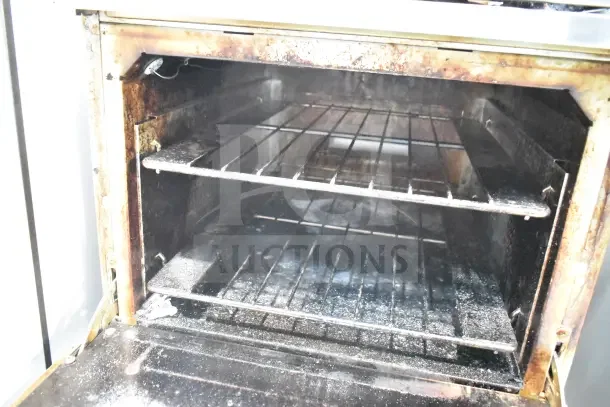 Vulcan commercial gas range oven interior, two shelves, visible signs of use, suitable for high-volume kitchens.