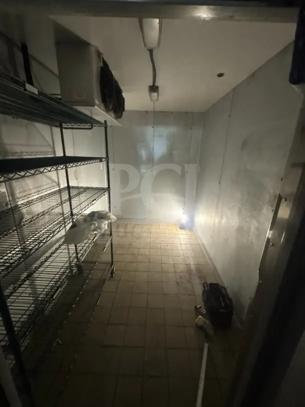 8'x12' walk-in box with evaporator fan, metal shelves, tiled floor, good condition, no contents included.