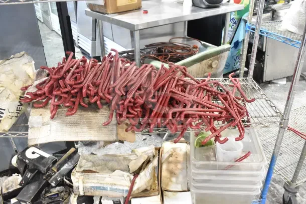 Metro shelving unit with contents, including red poly bins and organized items. Note: Buyer must dismantle.
