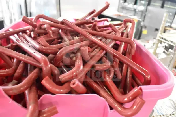 Poly bin filled with red metal hooks, part of a Metro shelving unit for auction. Buyer must dismantle.