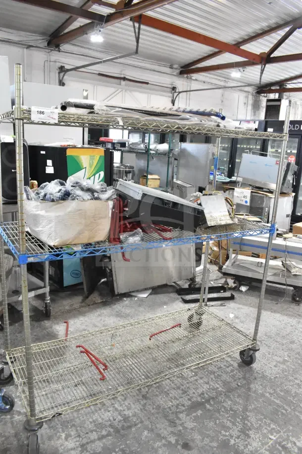 Metro Style 3-tier shelving unit on commercial casters, includes contents like cash drawer. Dismantling required.