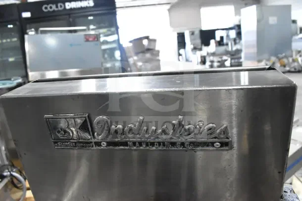 BK Industries commercial pressure fryer on casters in stainless steel. Features logo plaque. Suitable for high-volume use.