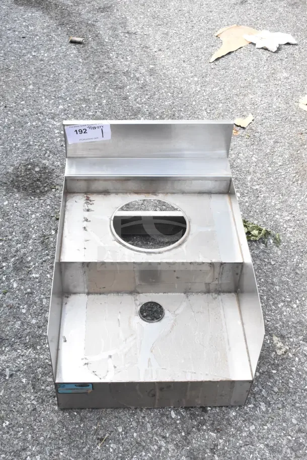 2-tier metal counter with circular cutouts and no legs, slight wear visible, auction tag 192 attached.