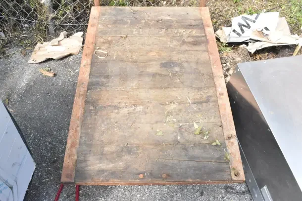 Flat Top Cart on Commercial Casters, worn wood surface, rusted metal frame, suitable for heavy-duty use.